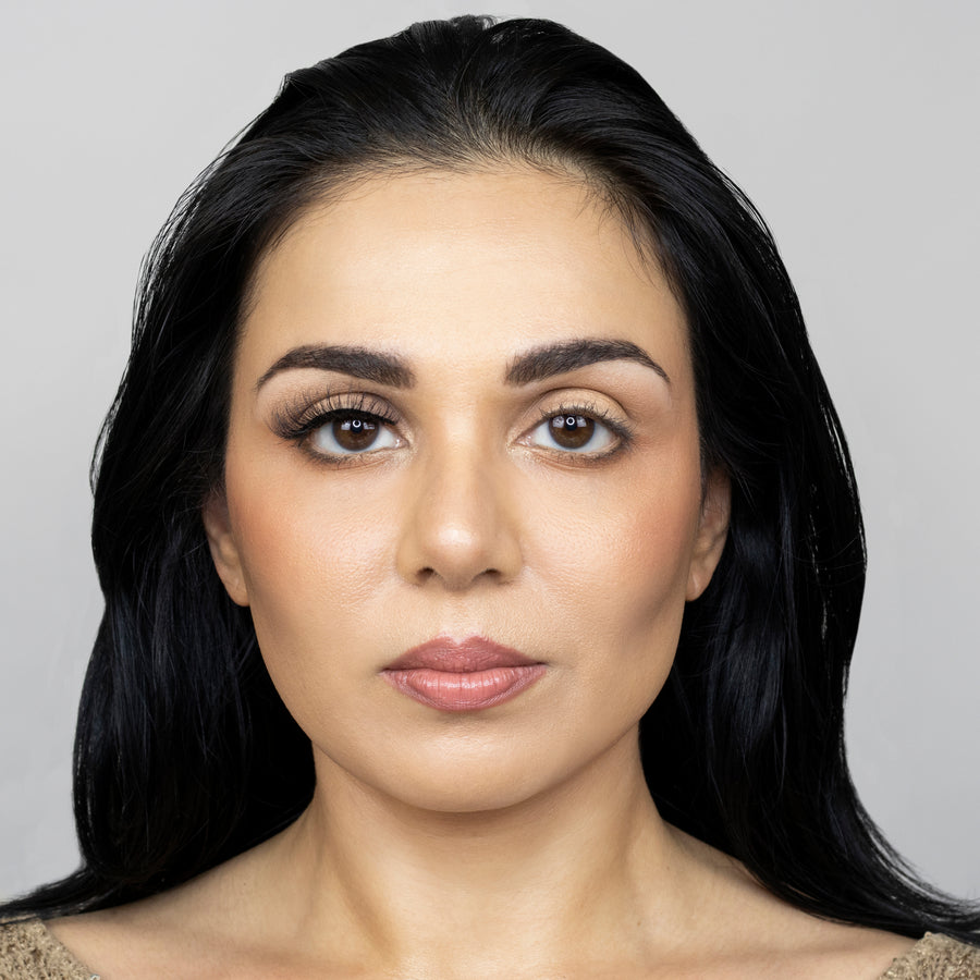 Full face image of a beautiful young woman looking straight ahead while wearing Suntarah Beauty 3D Faux Mink False Strip Eyelash in style F-102 on right eye only, and no false lash on left eye. There is a subtle but appealing difference in appearance between both eyes. Right eye is accentuated while appearing natural.