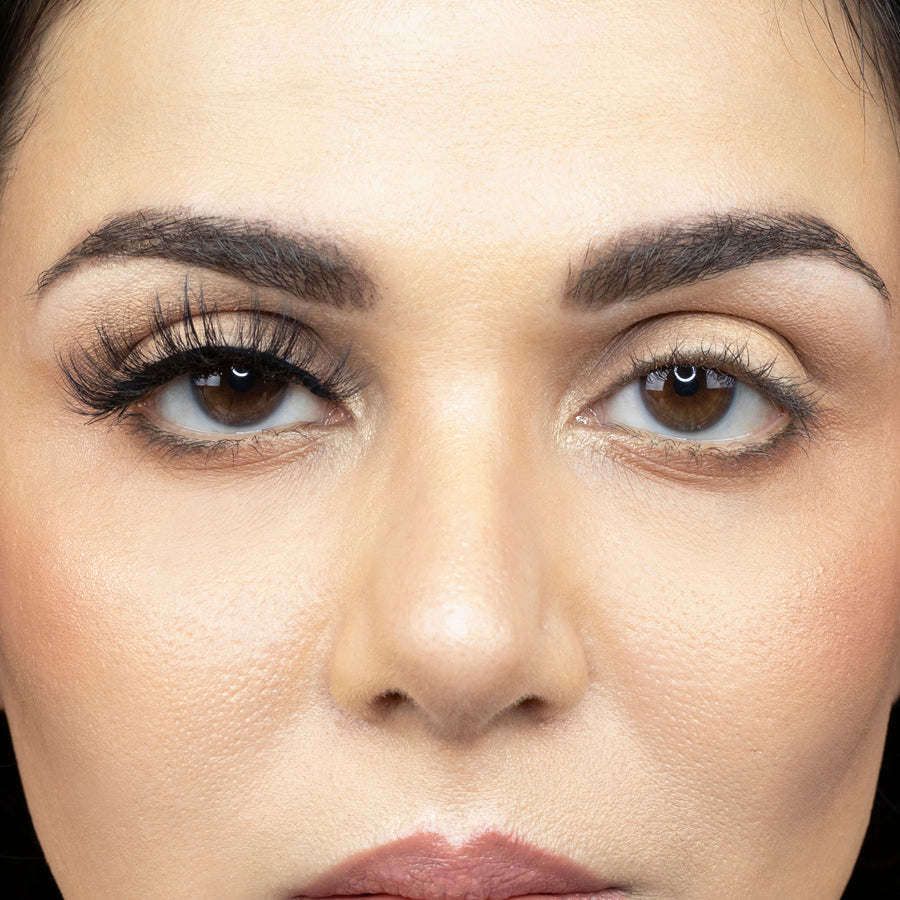 Close up of a young woman wearing Suntarah Beauty 3D Faux Mink False Strip Eyelash in Style F-104 on right eye only. There is a significant difference between her eyes. Eye with the false lash is accentuated and has a doll like look.