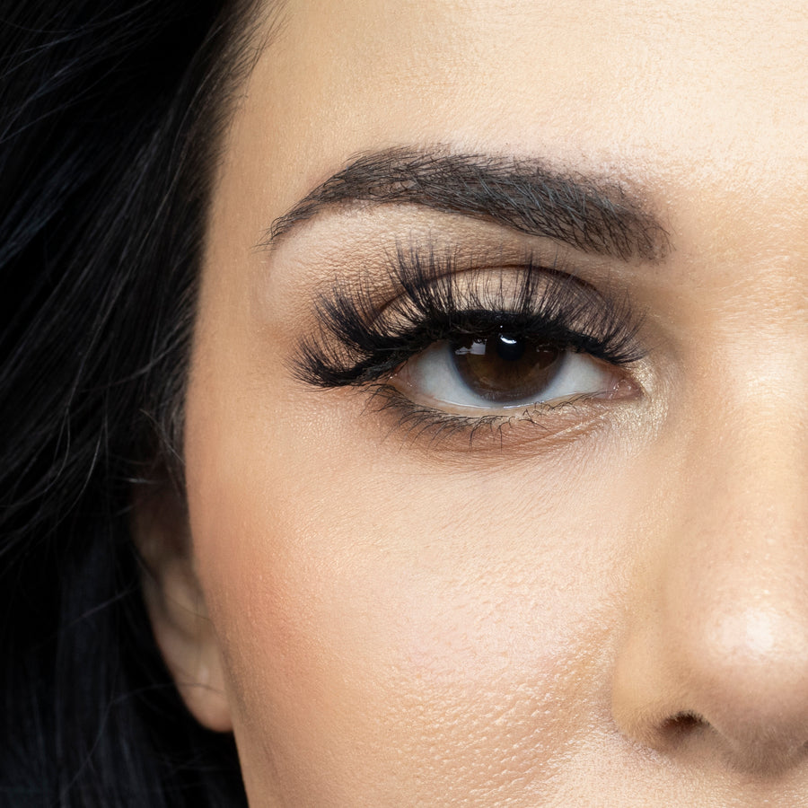 Close up of a young woman's right eye looking straight ahead and wearing Suntarah Beauty 3D Faux Mink False Strip Lash in F-108. Lash appears dramatic, glamorous, and doll like.