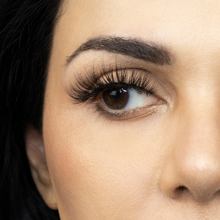 Close up of woman’s right eye while wearing Suntarah Beauty 3D Premium Synthetic false strip eyelash in style S-220.  Woman is looking to the side.  