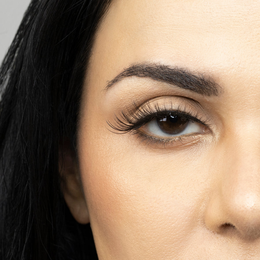 Close up of woman’s right eye while wearing Suntarah Beauty 3D Premium Synthetic false strip eyelash in style S-221.  Woman is looking straight ahead.  