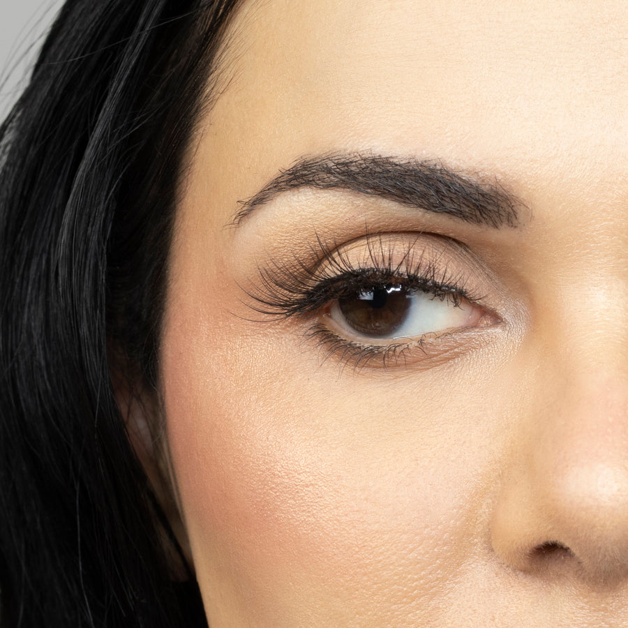 Close up of woman’s right eye while wearing Suntarah Beauty 3D Ultra Light Synthetic false strip eyelash in style SL-331.  Woman is looking to the side.  