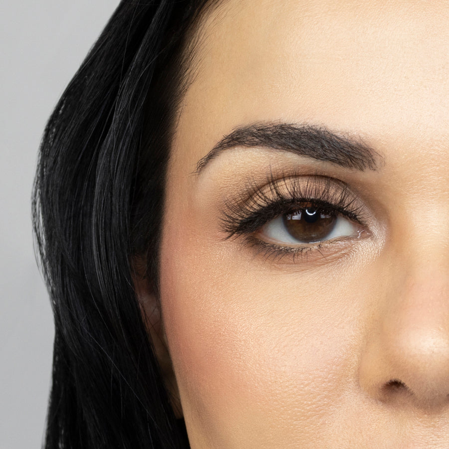 Close up of woman’s right eye while wearing Suntarah Beauty 3D Ultra Light Synthetic false strip eyelash in style SL-334.  Woman is looking straight ahead.  