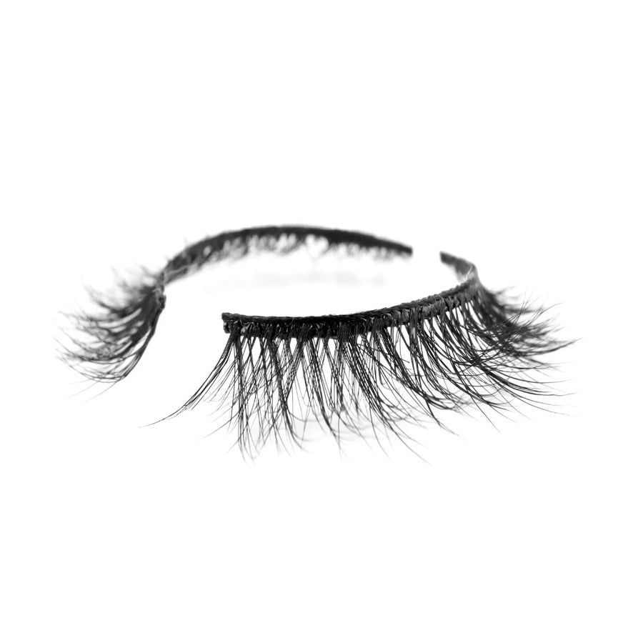 F-101 Natural Looking Suntarah Beauty 3D Faux Mink False Strip Eyelash Lying on Flat White Surface on an Angle.  Natural Wispy Lash with Strong Flexible Black Band