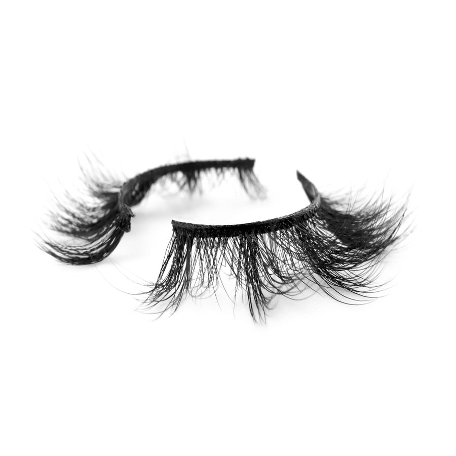 Suntarah Beauty 3D Faux Mink False Strip Eyelash in Style F-104. Lash has medium-light clusters, a round shape, and a black band. Lash is shown at an angle against a white backdrop.