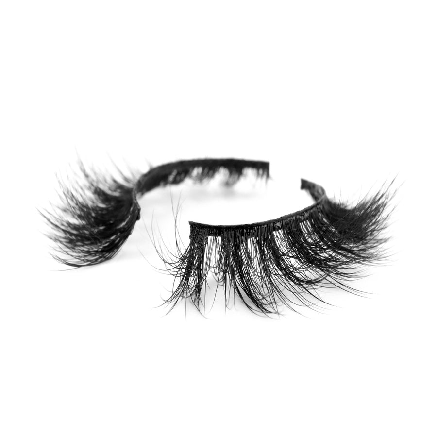 Suntarah Beauty 3D Faux Mink False Strip Eyelash in Style F-105. Lash has medium volume, a tapered shape, and a black strong, flexible band. Photo shows lash at an angle against a white backdrop.