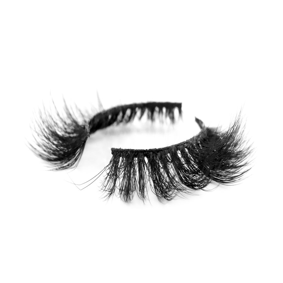 Suntarah Beauty 3D Faux Mink False Strip Eyelash in Style F-106. Medium volume lash with dynamic clusters and strong, flexible black band.  Lash is placed on an angle against white backdrop.