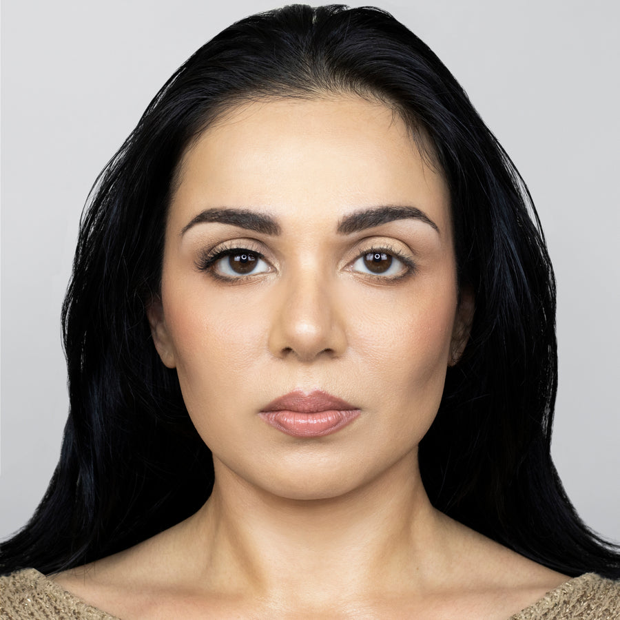 Full face of a young beautiful woman wearing Suntarah Beauty 3D Faux Mink False Strip Eyelash in Style F-101 on right eye only. There is a pleasing difference between her eyes. Eye with the false lash is slightly accentuated with a very natural looking wispy false lash.