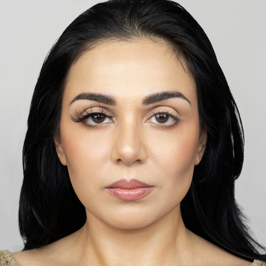 Full face showing of a young beautiful woman wearing Suntarah Beauty 3D Faux Mink False Strip Lash on her right eye, and no false lash on her left eye. Her right eye appears accentuated with a foxy and wispy look.