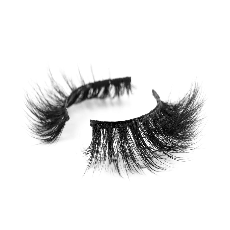 Suntarah Beauty Faux Mink False Strip Eyelash in style F104 with black band, round shape, and medium volume.  Lash is at an angle, showing its beautiful curl, against a white backdrop.