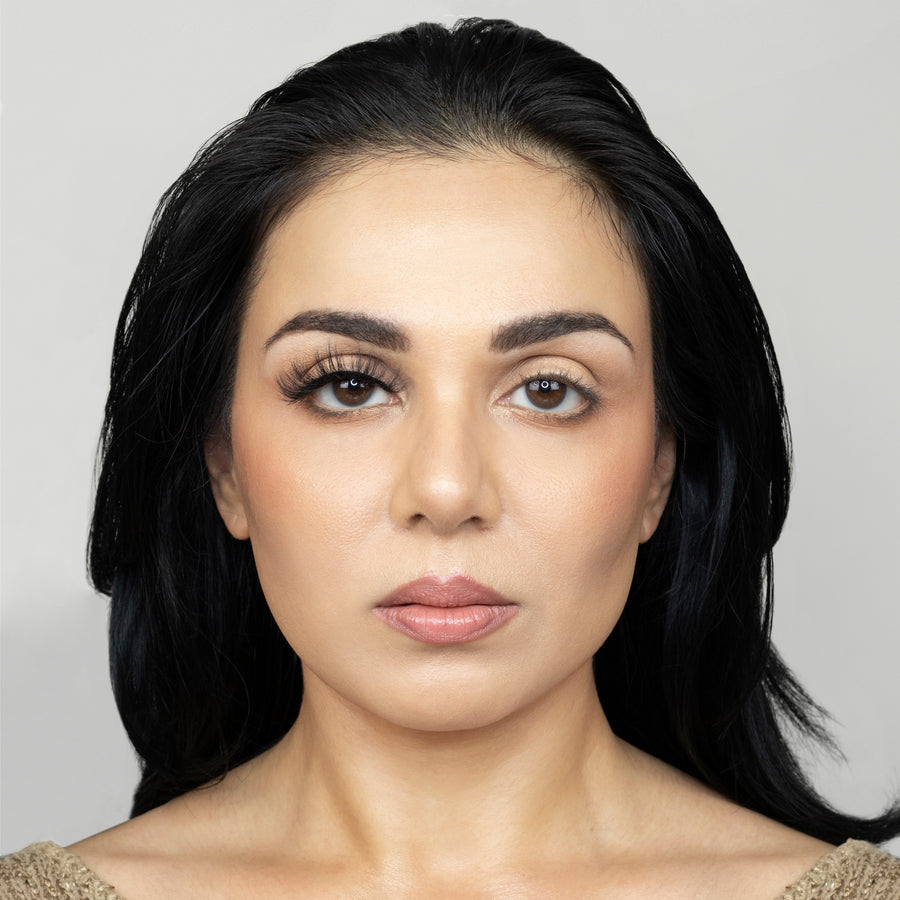 Close up of a young woman wearing Suntarah Beauty 3D Faux Mink False Strip Eyelash in Style F-104 on right eye only. There is a significant difference between her eyes. Eye with the false lash is accentuated and has a doll like look.