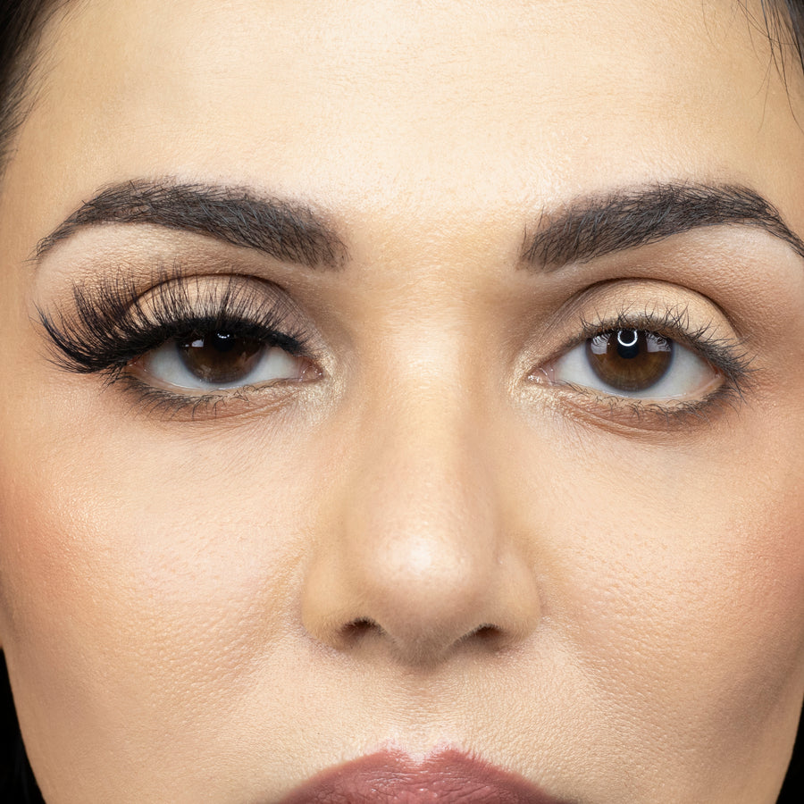 Close up image of young woman wearing Suntarah Beauty 3D Faux Mink False Strip Eyelash in Style F-106 on right eye. Image shows a significant difference between appeal of both eyes. Right eye with lash is accentuated and has a sultry appeal.
