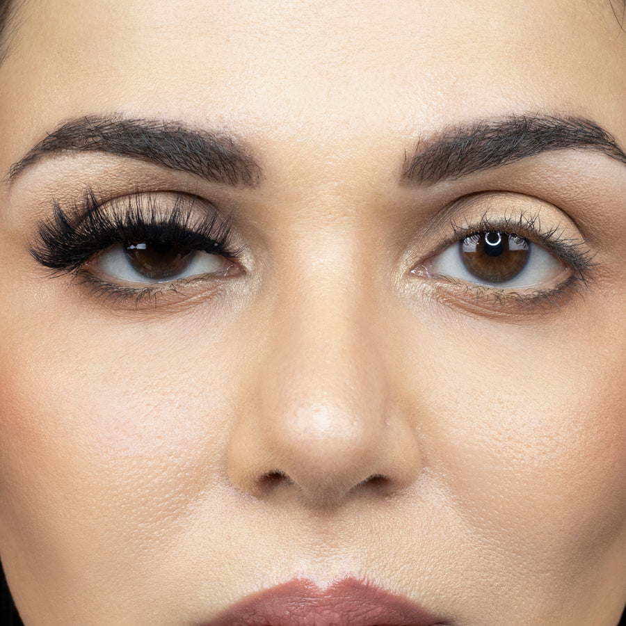Suntarah Beauty 3D Faux Mink False Strip Eyelash in Style F-109. Close up picture of young woman wearing the false lash only on her right eye. Image shows significant difference between the eyes.  Her right eye looks very glamorous and accentuated.  