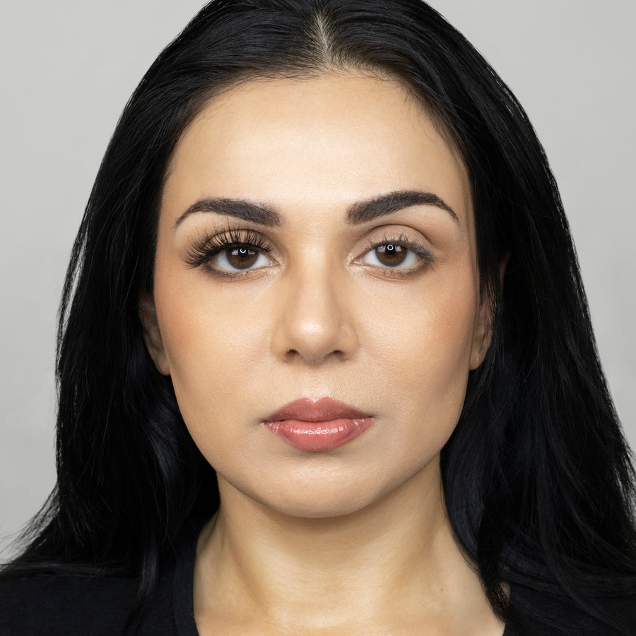 Full face of young beautiful woman wearing Suntarah Beauty Premium Synthetic Strip Eyelash in Style S-220 on right eye only. There is a significant difference in appeal between both her eyes.  Her right eye is glamorously accentuated with a bold, wispy, and gorgeous false strip lash.