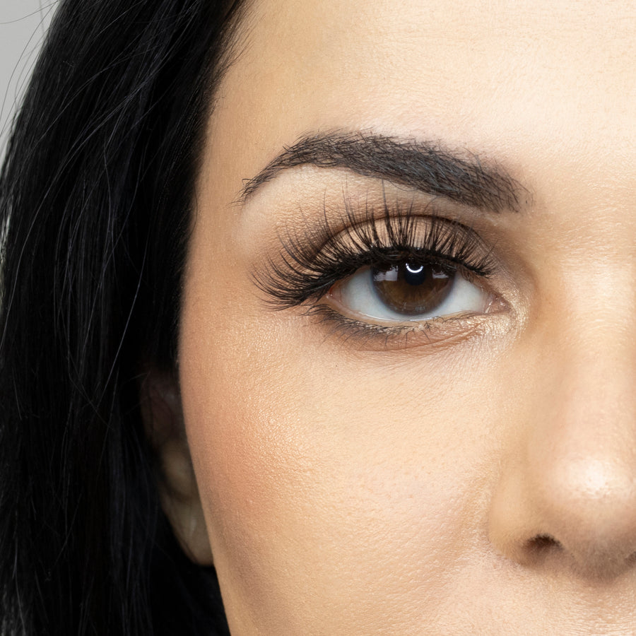 Close up of woman’s right eye while wearing Suntarah Beauty 3D Premium Synthetic false strip eyelash in style S-220.  Woman is looking straight ahead.  