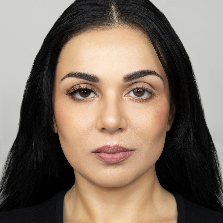 Full face of young beautiful woman wearing Suntarah Beauty Premium Synthetic Strip Eyelash in Style S-223 on right eye only.  There is a significant difference in appeal between both her eyes.  Her right eye is accentuated with a sensual, bold, glamorous false strip lash.  