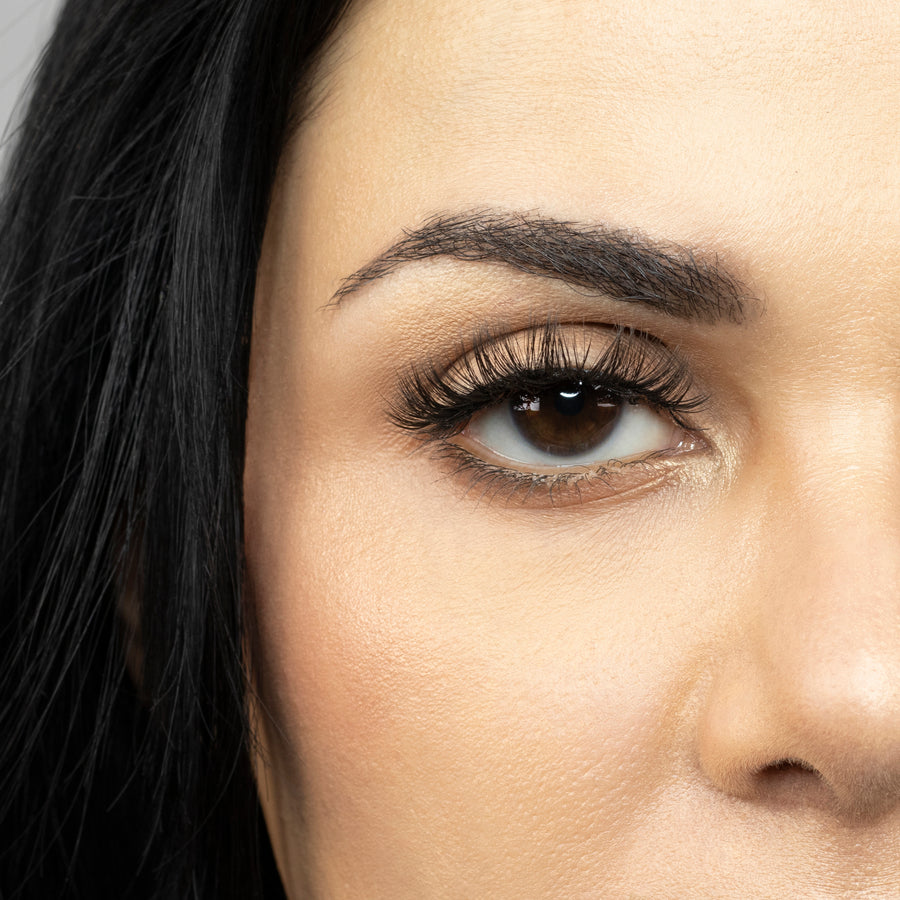 Close up of woman’s right eye while wearing Suntarah Beauty 3D Premium Synthetic false strip eyelash in style S-223.  Woman is looking straight ahead.  