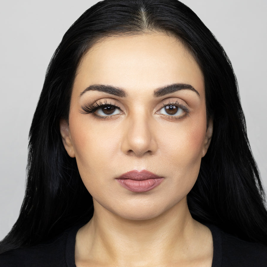 Full face of young beautiful woman wearing Suntarah Beauty Premium Synthetic Strip Eyelash in Style S-224 on right eye only. There is a significant difference between her eyes. Her right eye is accentuated with a sensual, foxy, and glamorous false strip lash.