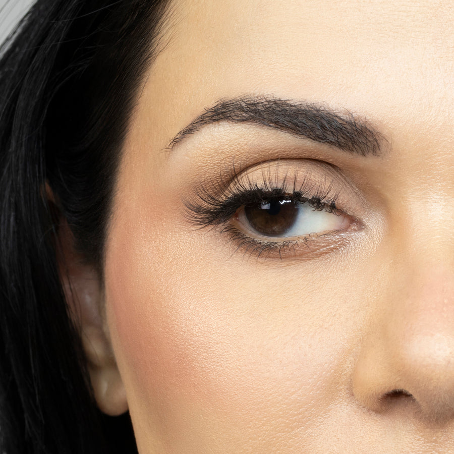 Close up of woman’s right eye while wearing Suntarah Beauty 3D Ultra Light Synthetic false strip eyelash in style SL-330.  Woman is looking to the side.  