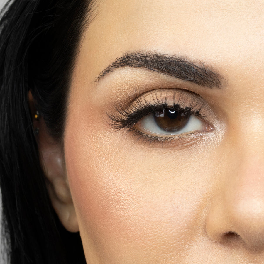 Close up of woman’s right eye while wearing Suntarah Beauty 3D Ultra Light Synthetic false strip eyelash in style SL-330.  Woman is looking straight ahead.  