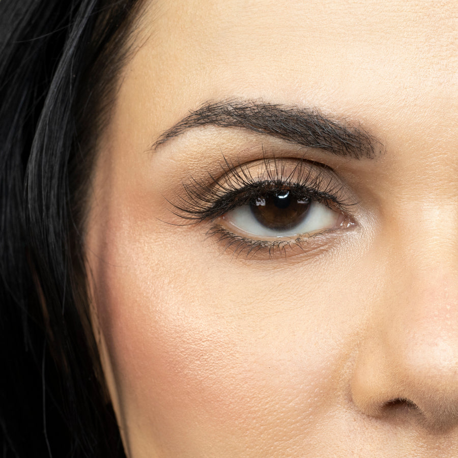 Close up of woman’s right eye while wearing Suntarah Beauty 3D Ultra Light Synthetic false strip eyelash in style SL-331.  Woman is looking straight ahead.  