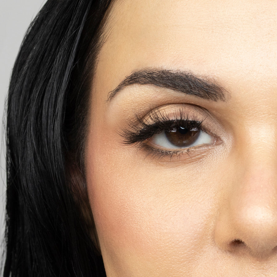 Close up of woman’s right eye while wearing Suntarah Beauty 3D Ultra Light Synthetic false strip eyelash in style SL-333.  Woman is looking straight ahead.  
