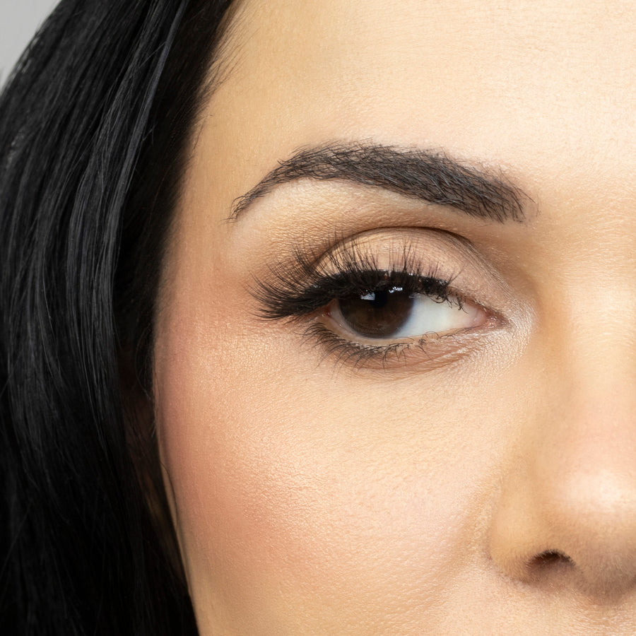 Close up of woman’s right eye while wearing Suntarah Beauty 3D Ultra Light Synthetic false strip eyelash in style SL-333.  Woman is looking to the side.  