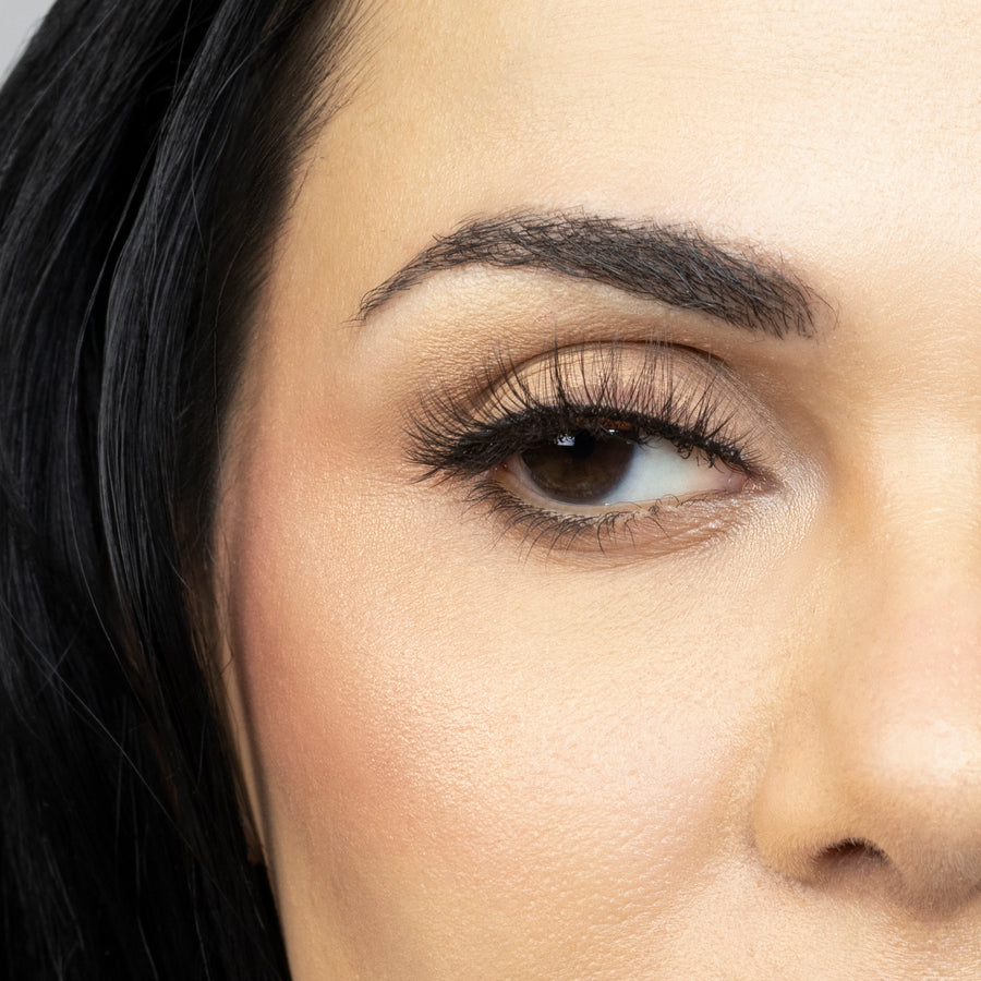 Close up of woman’s right eye while wearing Suntarah Beauty 3D Ultra Light Synthetic false strip eyelash in style SL-334.  Woman is looking to the side.  