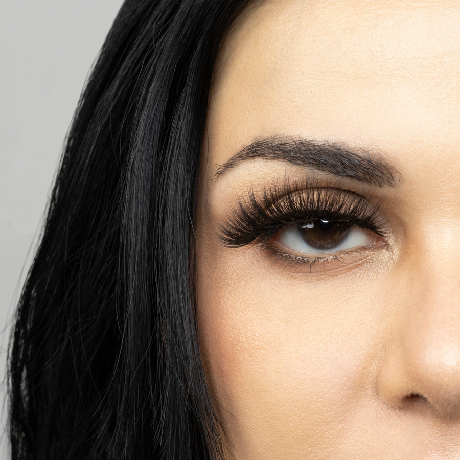 Close up of woman’s right eye while wearing Suntarah Beauty 3D Premium Synthetic false strip eyelash in style S-225.  Woman is looking straight ahead.  